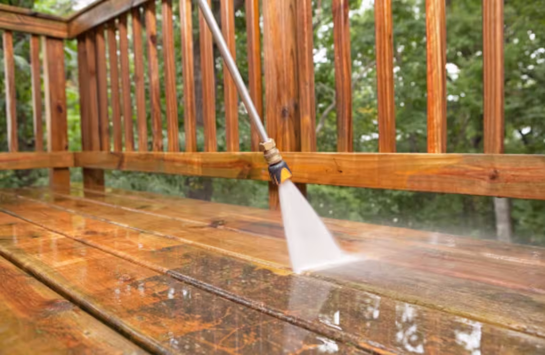 Pressure washing a wood deck railing and floor